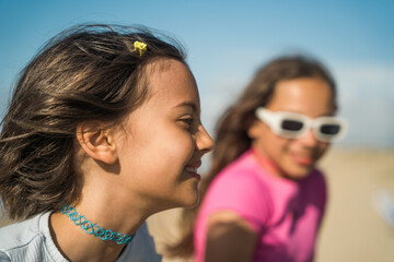 Wall Mural - Happy girl enjoying of the summer while sitting at the seashore with her bestie