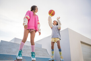 Wall Mural - Two sisters having fun while playing basketball and spending time at the open air stadium