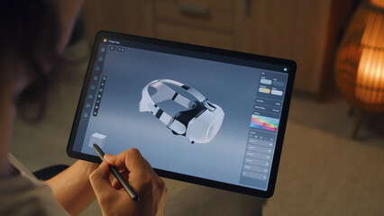 Poster - Young male 3D designer drawing and creating 3D prototype of VR headset in professional design application on tablet using digital pencil