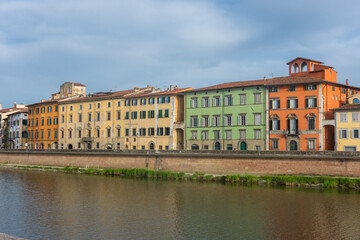 Wall Mural - Pisa, Italy,  14 April 2022: View of the colorful banks of Arno river