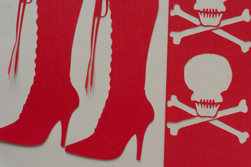 Sticker - red paper stencil with skull heads and glyph or dingbat cutout of tall lace up stiletto boots