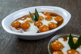 Kolak biji salak ubi kuning, indonesian dessert made from sweet potatoes and sago flour which are shaped into rounds, then boiled. 
It has a delicious and chewy taste