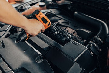 Automobile mechanic repairman hands repairing a car engine automotive workshop