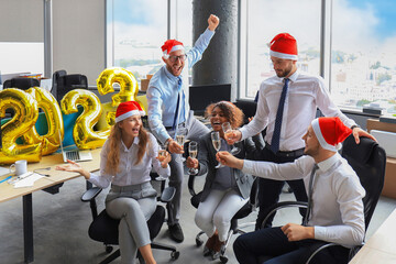 Wall Mural - Business people are celebrating holiday in modern office drinking champagne and having fun in coworking. Merry Christmas and Happy New Year 2023.