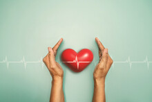 Medical Red Heart With Cardiogram Chart Line In Hand On A Light Green Background, Heart Health Care Concept For World Heart Day