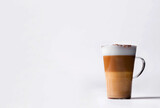 Milk coffee or latte macchiato glass, on white background. Italian coffee with milk and layers. Gourmet coffee.