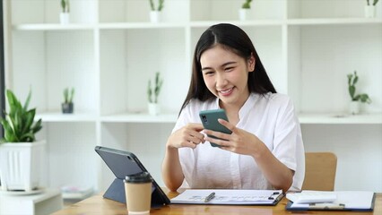 Wall Mural - young businesswoman looking at financial information from a mobile phone, she is checking company financial documents, she is a female executive of a startup company. Concept of financial management.