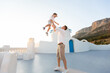 © Studio Peace - Father throws his son into the air at sunset. on the island of Santorini, Greece.