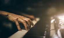 Close-up Of A Music Performers Hand Playing The Piano. Hands Of Musician Playing Keyboard In The Music Room For Pianists To Practice Before The Performance. Photo Piano In Retro Style.