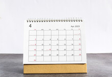April 2023 Desk Calendar For Planners And Reminders On A Black Table On A White Background.