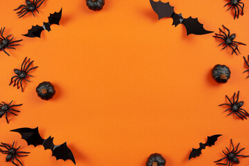 Wall Mural - happy halloween flat lay mockup with black pumpkins, spiders and bats on orange background. holiday 