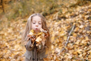 Wall Mural - Portrait of a fashion little girl having fun in autumn forest