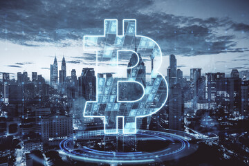 Poster - Creative glowing bitcoin hologram on blurry city background. Cryptocurrency, finance and tech concept. Double exposure.