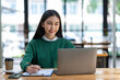 © crizzystudio - Asian businesswoman working with laptop at her desk in the modern office