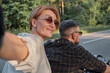 © perfectlab - Middle age couple riding a motorcycle having fun and taking selfies