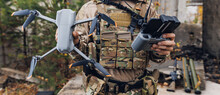 Concept Military Use Of Aerial Drone In Army. Soldier Engineer Holds An Automatic Quadrocopter In Hands