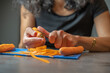 © Esta Webster - épluchage de carottes pour la réalisation d'un plat en gros plan avec fondu au flou