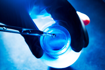 Wall Mural - blue glass test tube,asian female scientist with test tubes doing research in clinical laboratories 