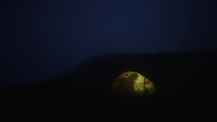 the tourist goes to bed and turns off the light in the tent. a night in the camp during a hike in th