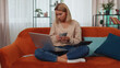 © Andrii Iemelianenko - Planning family budget. Young woman counting money cash, calculate domestic bills working on laptop at home. Girl satisfied of income and saves money for a planned vacation, gifts, future expenses