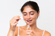 © luismolinero - Young Pretty caucasian woman isolated on white background holding a serum while smiling. Close up portrait