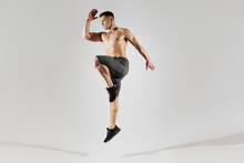 Confident Young Man With Perfect Body Jumping Against White Background