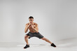 © gstockstudio - Confident fit man with perfect body exercising against white background