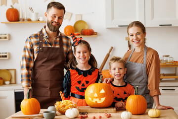 Wall Mural - Happy family mother, father and kids  looking at camera while  make jack-o-lantern from pumpkin, getting ready for halloween