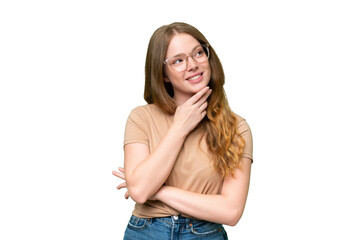 Young pretty woman over isolated background looking up while smiling