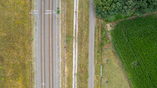 Aerial View Of Railway Through Countryside Landscape, Top Down Perspective From Drone Pov. High Quality Photo