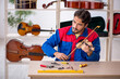 © Elnur - Young man repairing musical instruments at workshop
