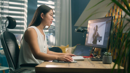 Poster - Asian woman creating 3D model of video game character in professional program using computer and digital tablet while working at home office