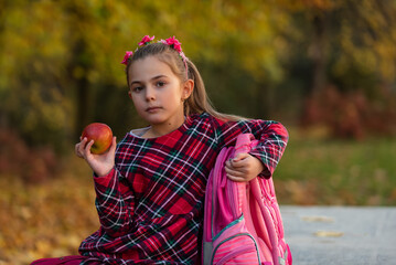 Wall Mural - A child girl eating healthy breakfast outdoors on the school lunch.