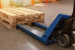© New Africa - Modern manual forklift with wooden pallets in warehouse, closeup