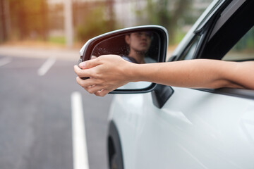 woman driver adjusting side view mirror a car. Journey, trip and safety Transportation concepts