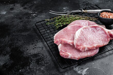 Raw Pork Cutlet Chop Steak For Fry On Pan With Herbs. Black Background. Top View. Copy Space