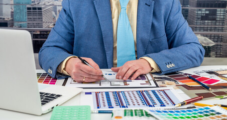 Wall Mural - designer man chooses colors for office work on apartment drawing.