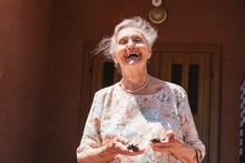 Senior Woman With Car Keys Laughing On Sunny Day