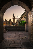 Fototapeta Big Ben - Big Ben and the Houses of Parliament, framed by an ancient, stone archway, across the river Thames
