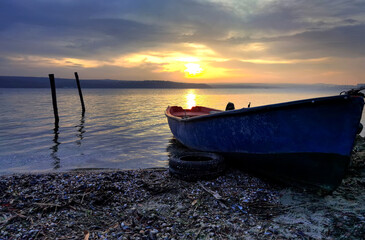 Wall Mural - beauty sunset with the lonely blue boat on the  beach