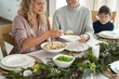 © gpointstudio - Caucasian woman sharing ravioli at the Christmas Eve