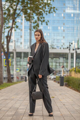 Wall Mural - Young sexy woman in male business suit posing on the street