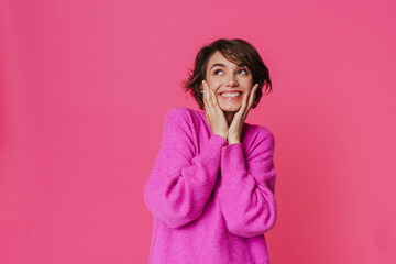 Wall Mural - Young white woman wearing sweater smiling and looking upward