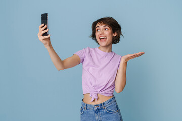 Wall Mural - White woman holding copyspace while taking selfie at cellphone