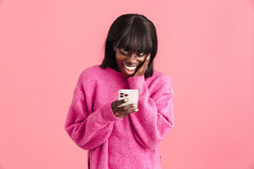 Young beautiful smiling african woman touching cheek and looking phone