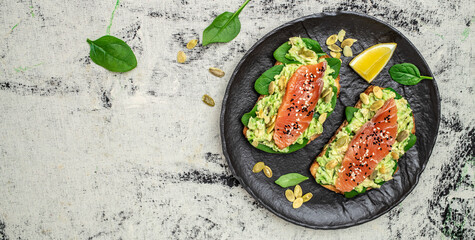 Wall Mural - Delicious breakfast or snack sandwich salmon, avocado, spinach, nuts, sunflower seeds, toast with red fish and guacamole. Healthy, clean eating. Vegan or gluten free diet. top view, copy space