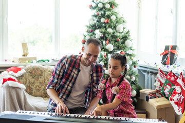 Wall Mural - father and daughter playing the piano at christmas