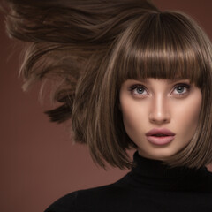 Wall Mural - Portrait of a beautiful brown-haired woman with a short haircut on a brown background