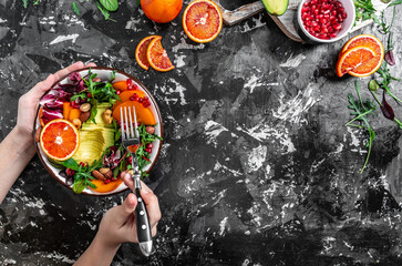 Canvas Print - Girls' hands holding Quinoa vegetable vegetarian buddha bowl avocado, blood orange, broccoli, watermelon radish, spinach, quinoa, pumpkin seeds. top view