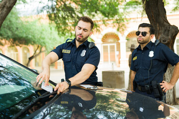 Wall Mural - Caucasian police agents leaving a parking fine in a car